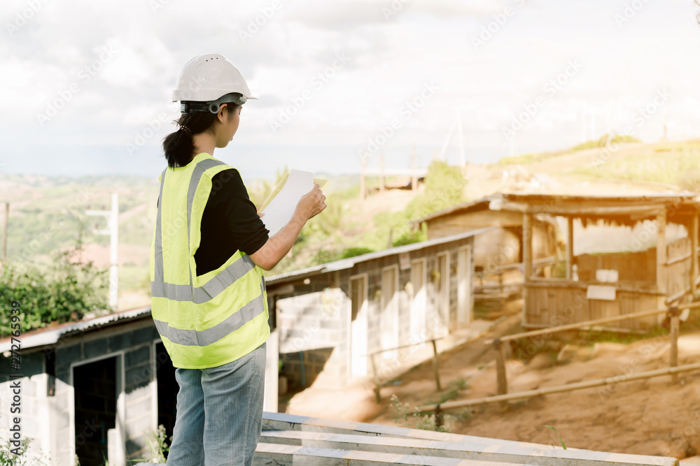 Asian female engineer Put on a white safety hat Wearing a green safety shirt Stand for construction inspection In the construction area Asian female engineer Put on a white safety hat Wearing a green safety shirt Stand for construction inspection In the construction area
