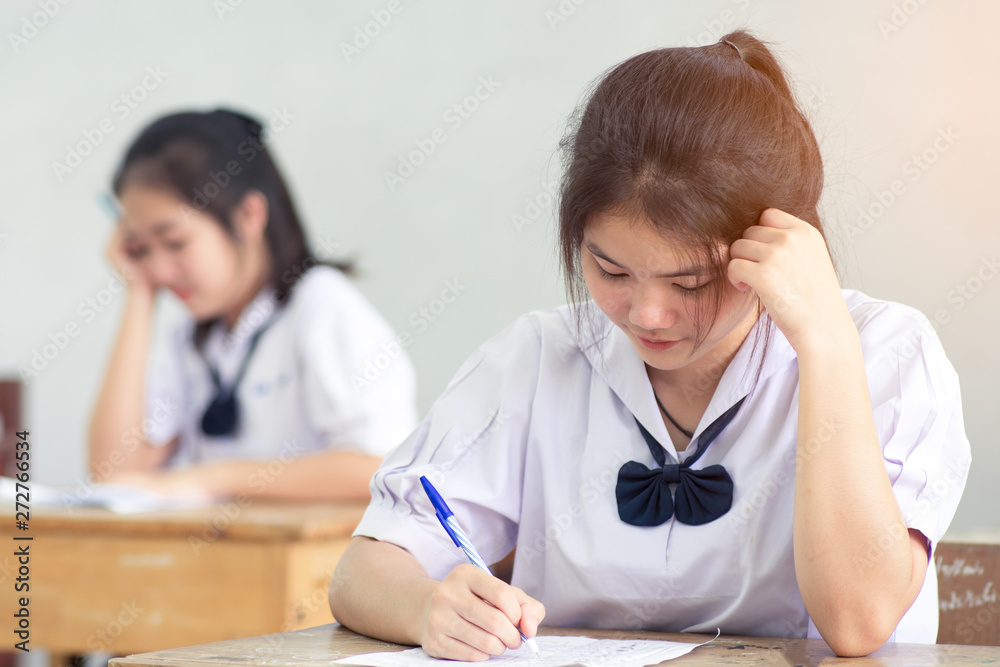 Asian girl student reading and writing exam with stress. Asian girl student reading and writing exam with stress.