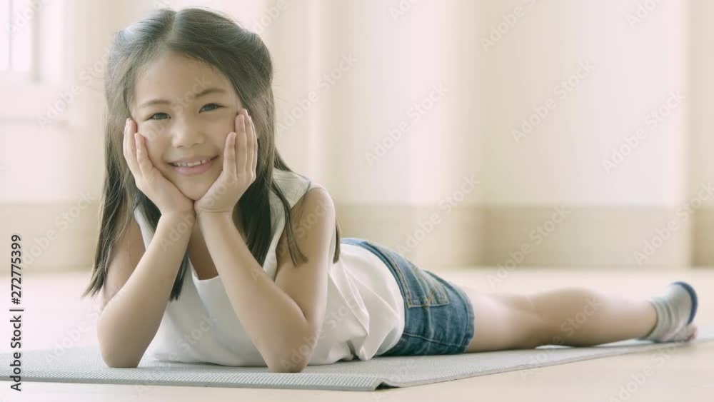 Portrait of a cute little Asian girl lying down on the floor Portrait of a cute little Asian girl lying down on the floor