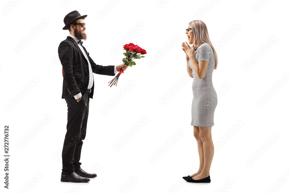 Man in a suit giving a bouquet of red roses to a surprised woman Man in a suit giving a bouquet of red roses to a surprised woman