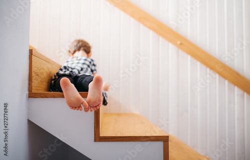 A rear view of small girl lying down on staircase. Copy space.