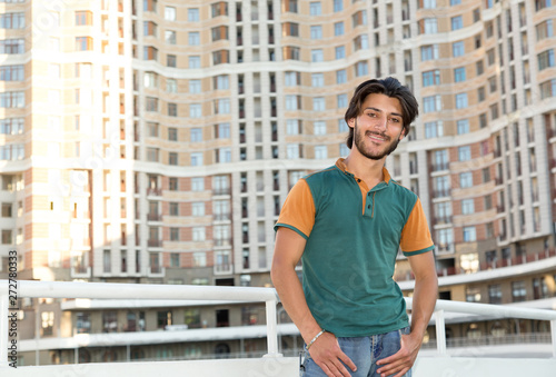 Brunette man against the background of the urban building.