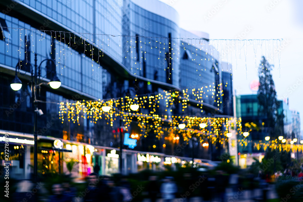 The background of the bokeh of the evening city. Festive Christmas New Year illuminations in city streets