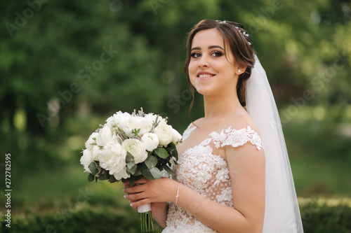 Beautiful bride in wedding dress walking in the park