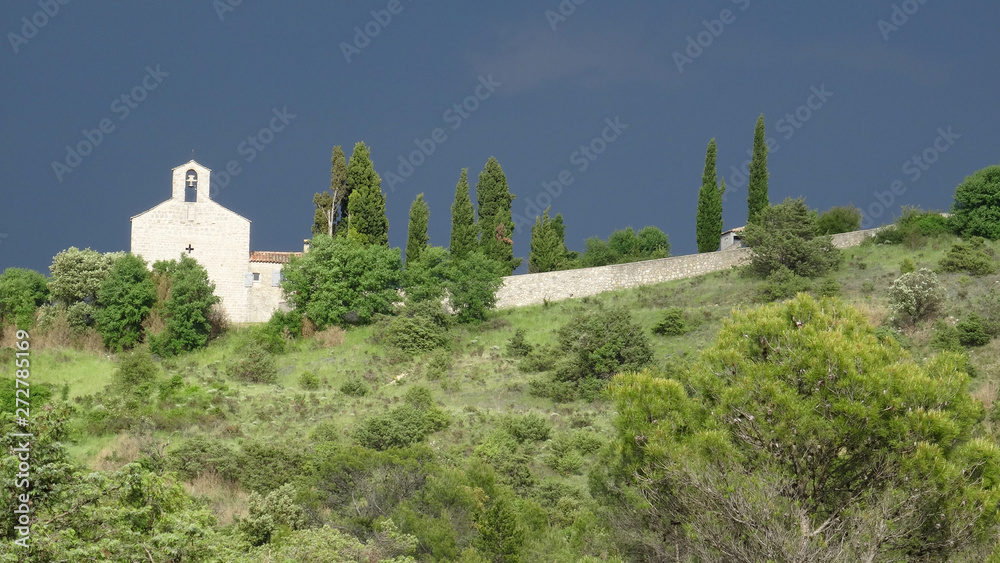 Small white chapel in landscape under a stormy sky