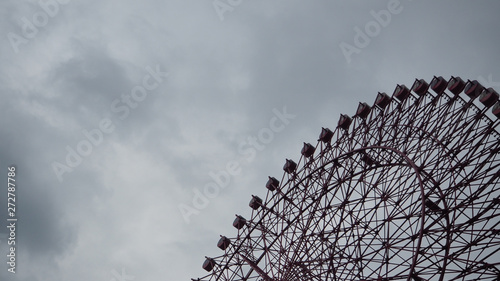 Ferris wheel with the sky’s overcast background at osaka japan.