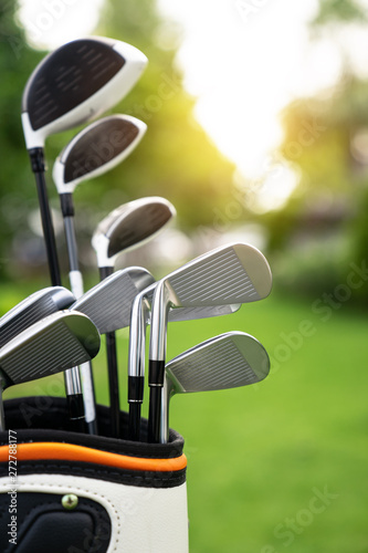 set of golf clubs over green field background,olf clubs drivers over green field background
