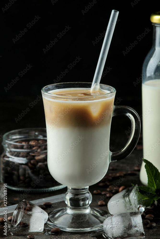 Ice latte or Iced coffee with milk and ice cubes in a glass beaker against a dark background. refreshing drink. summer drink. Ice latte or Iced coffee with milk and ice cubes in a glass beaker against a dark background. refreshing drink. summer drink.