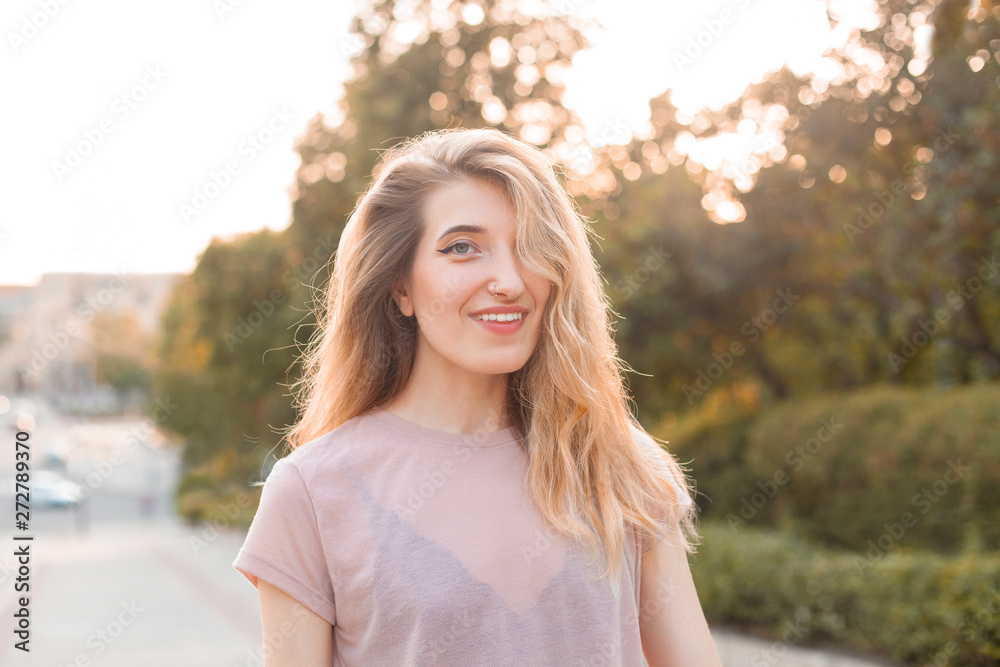 Beautiful young woman walking in the city under sunlight. Beautiful young woman walking in the city under sunlight.