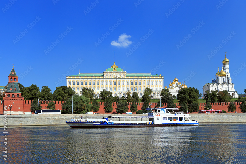 Naklejka premium River tourist ship sails past the Moscow Kremlin on a warm summer day