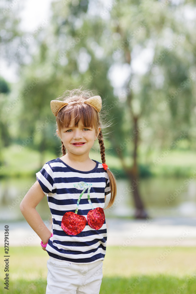Fototapeta premium Young girl posing outdoors.Looking at camera