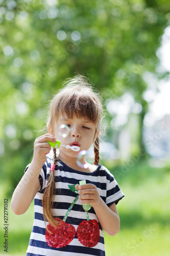 Adorable little girl blowing bubble
