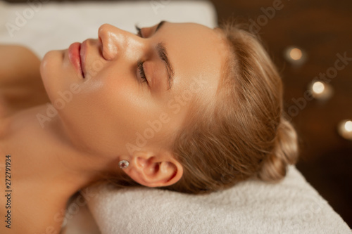 Appealing woman with flawless skin lying on folded towel