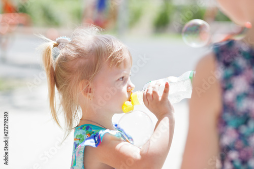 Adorable child baby drinking water from bottle