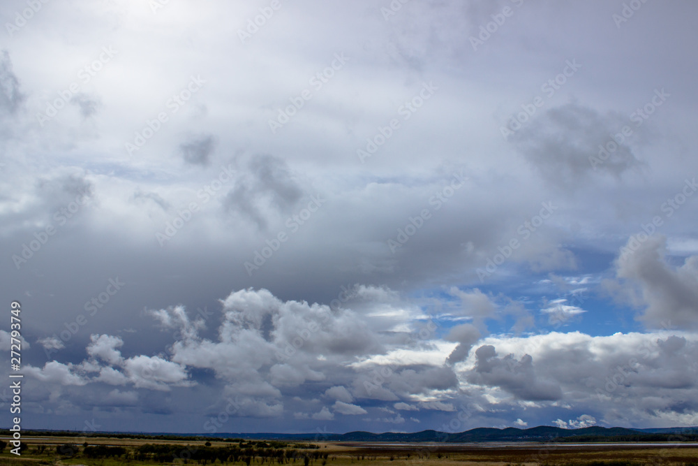 Cloudy blue sky on the horizon of Russian fields and mountains. Summer forest on a sunny day. Cloudy blue sky on the horizon of Russian fields and mountains. Summer forest on a sunny day.