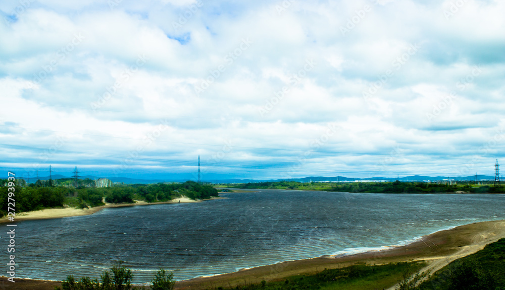 Cloudy blue sky on the horizon of Russian fields and mountains. Summer forest on a sunny day.