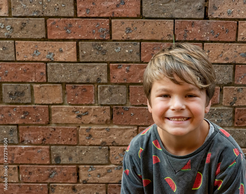 little boy smiling and looking goofy in a water melon shirt