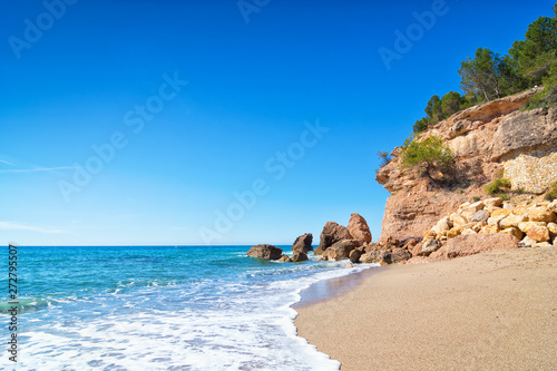 Beautiful deserted beach and huge rocks on the background. Miami Platja, Costa Dorada Coast, Tarragona, Spain