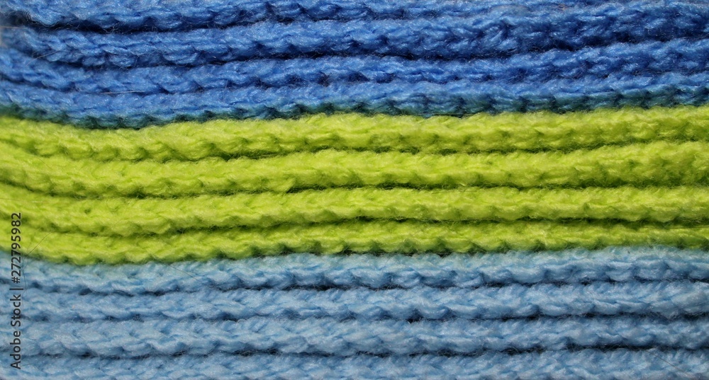 A pile of bright green and blue knitted elements. Warm and soft wallpaper, pattern, background