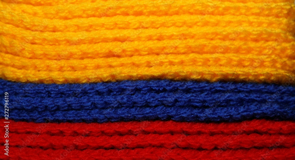 A pile of bright yellow, blue nd green knitted elements. Warm and soft wallpaper, pattern, background. Colombian flag
