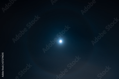 Round halo surrounding moon at night
