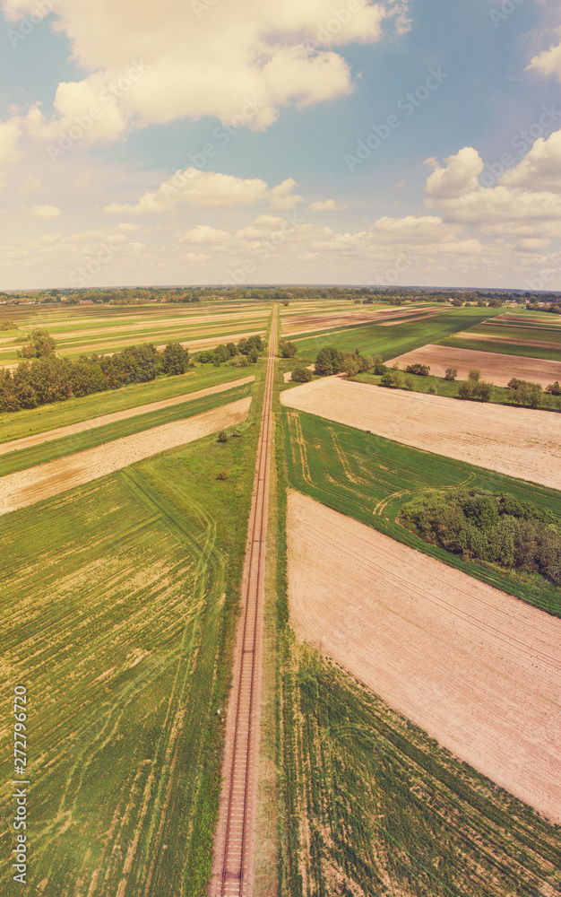 Railroad track amongst rural area aerial view