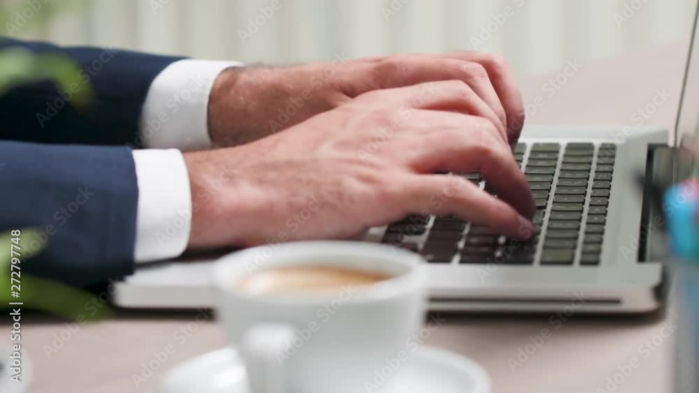Close up, selective focus, of male hands typing on laptop keyboard