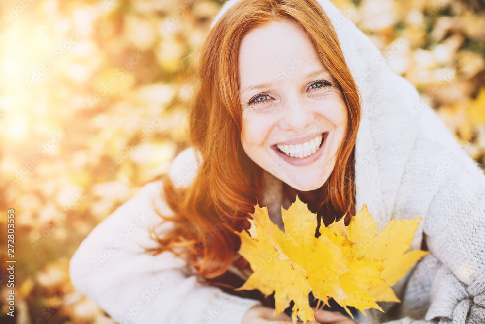 Portrait Gesicht einer rothaarigen Frau in Herbstlandschaft mit blauen Augen 