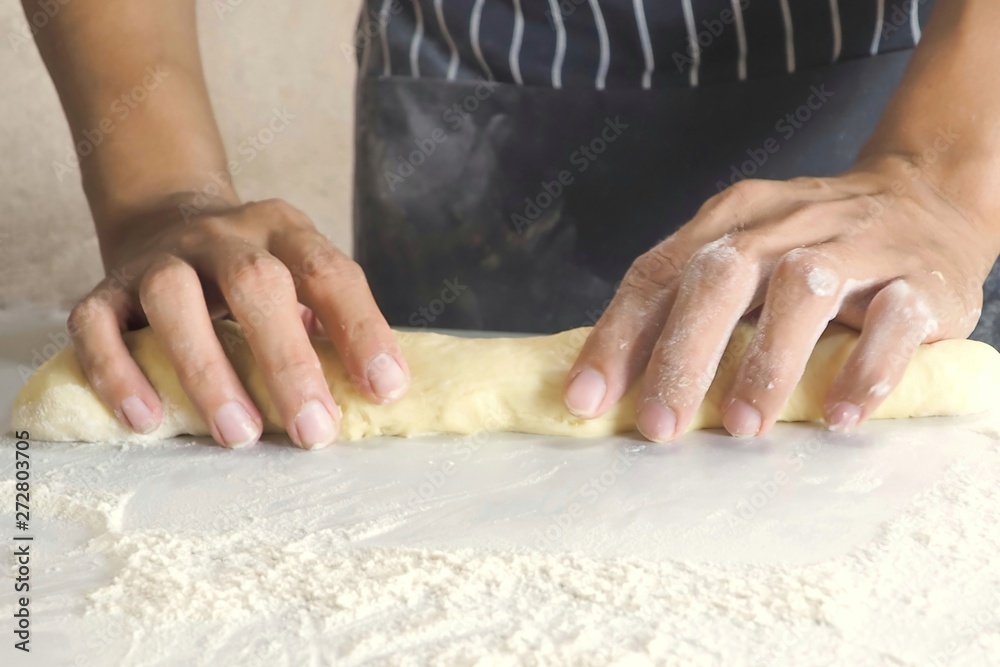 hands of baker kneading dough