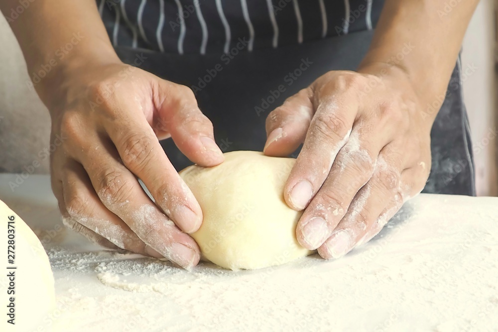 Fototapeta premium hands of baker kneading dough