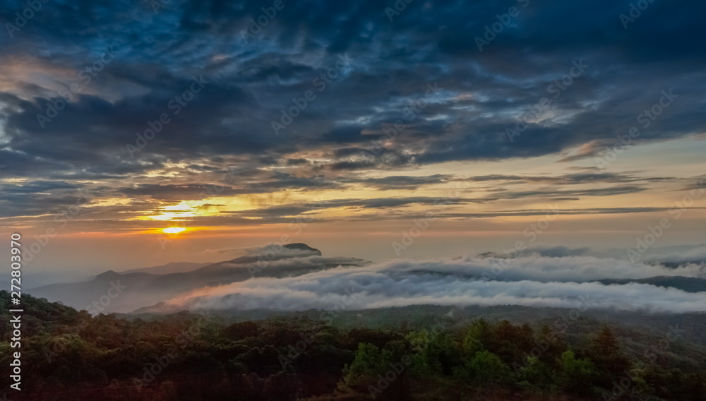 sunrise at Doi Inthanon, Km. 41 view point, mountain view misty morning on top hill panorama 180 degrees with sea of mist in valley and yellow sun light in the sky background, Chiang Mai, Thailand.
