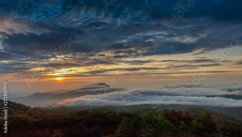 sunrise at Doi Inthanon  Km. 41 view point  mountain view misty morning on top hill panorama 180 degrees with sea of mist in valley and yellow sun light in the sky background  Chiang Mai  Thailand.