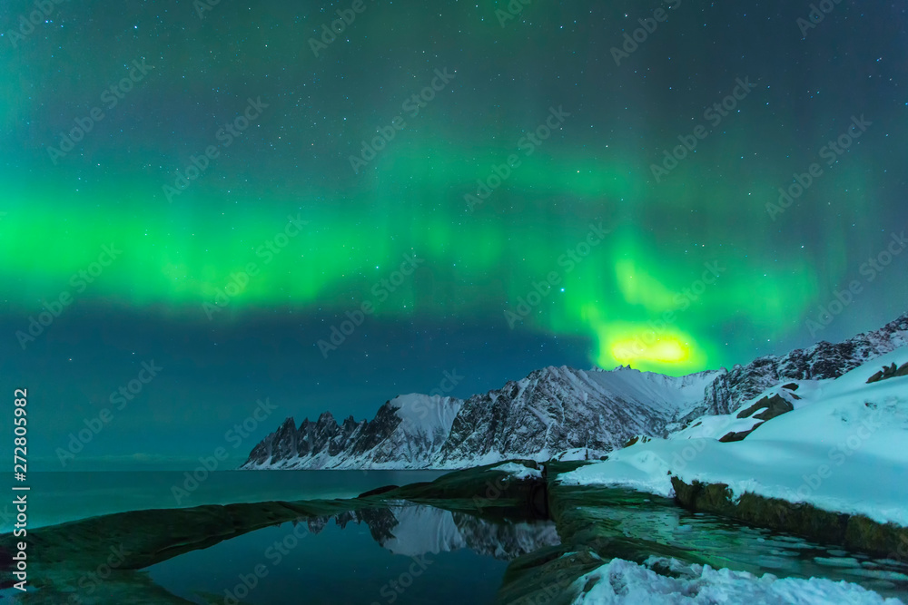 Naklejka premium Northern lights with beautiful mountains by the ocean in Norway