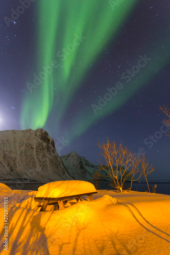 Northern light in kamping at night against the backdrop of beautiful mountains photo