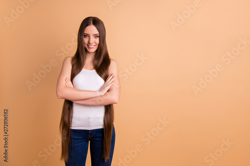 Close up photo beautiful amazing her she lady very long brown hair show great condition curls look confident interested curious wear casual white tank-top jeans denim isolated pastel beige background