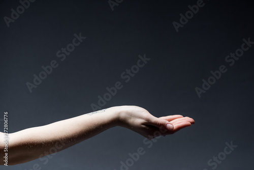 cropped view of woman holding hand up on dark