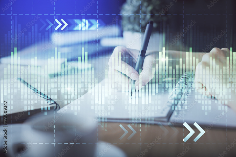 Financial forex graph drawn over hands taking notes background. Concept of research. Multi exposure Financial forex graph drawn over hands taking notes background. Concept of research. Multi exposure