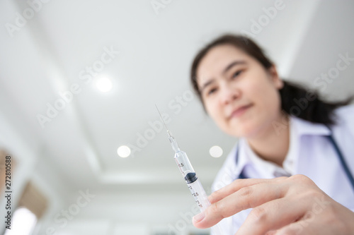 Asian female doctor holding syringe medical injection in hand young nurse with medicine plastic vaccination equipment with needle at hospital syringe vaccination medicine health care concept