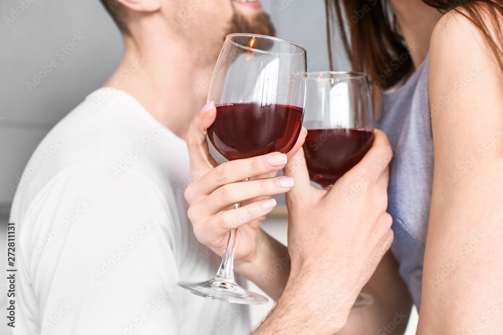 Happy young couple drinking wine at home