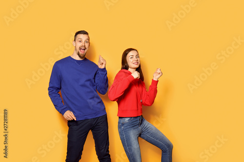 Dancing young couple on color background