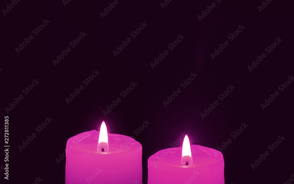 Shining a Pair of Vivid Pink Candles on Black Background with Copy Space Shining a Pair of Vivid Pink Candles on Black Background with Copy Space