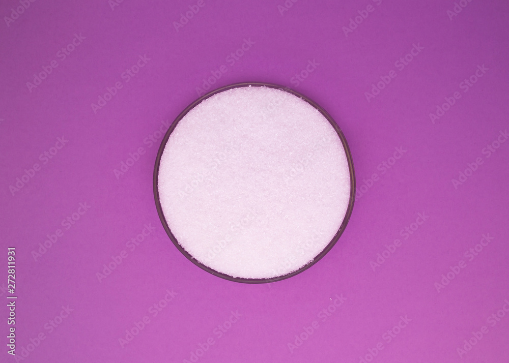 White sea salt in round cap on a purple background White sea salt in round cap on a purple background