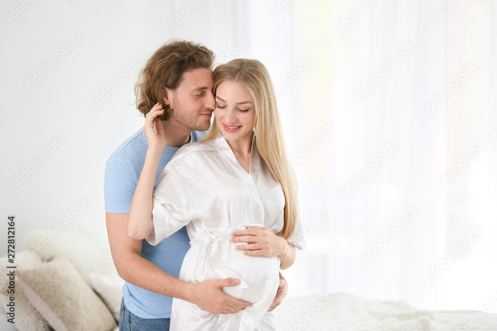 Happy young pregnant couple at home