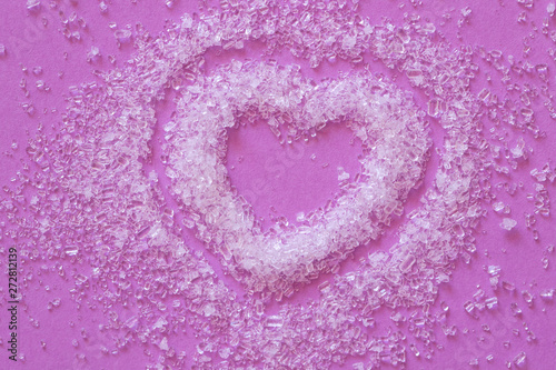 White sea salt crystals heart on a purple background