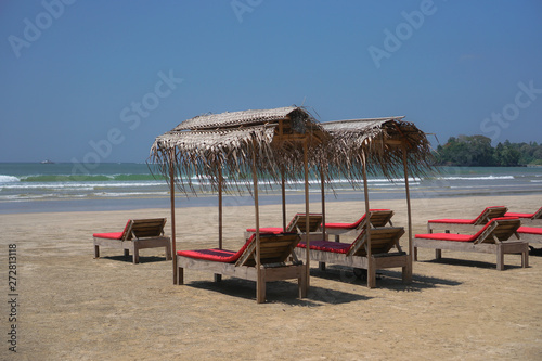 Beautiful Sri Lankan view of the Indian Ocean with sun loungers on the beach. Summer holidays in Asia. Stock photos