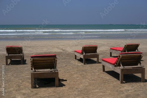 Beautiful Sri Lankan view of the Indian Ocean with sun loungers on the beach. Summer holidays in Asia. Stock photos