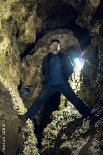 Man exploring huge cave. Adventure travellers dressed. extreme vacation, tourist route. ancient crystal formations, geology, village Kryvche. Ukraine