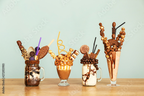 Delicious freak shakes on table against grey background photo