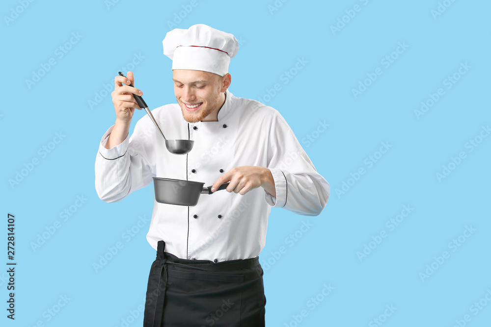Handsome male chef with sauce on color background