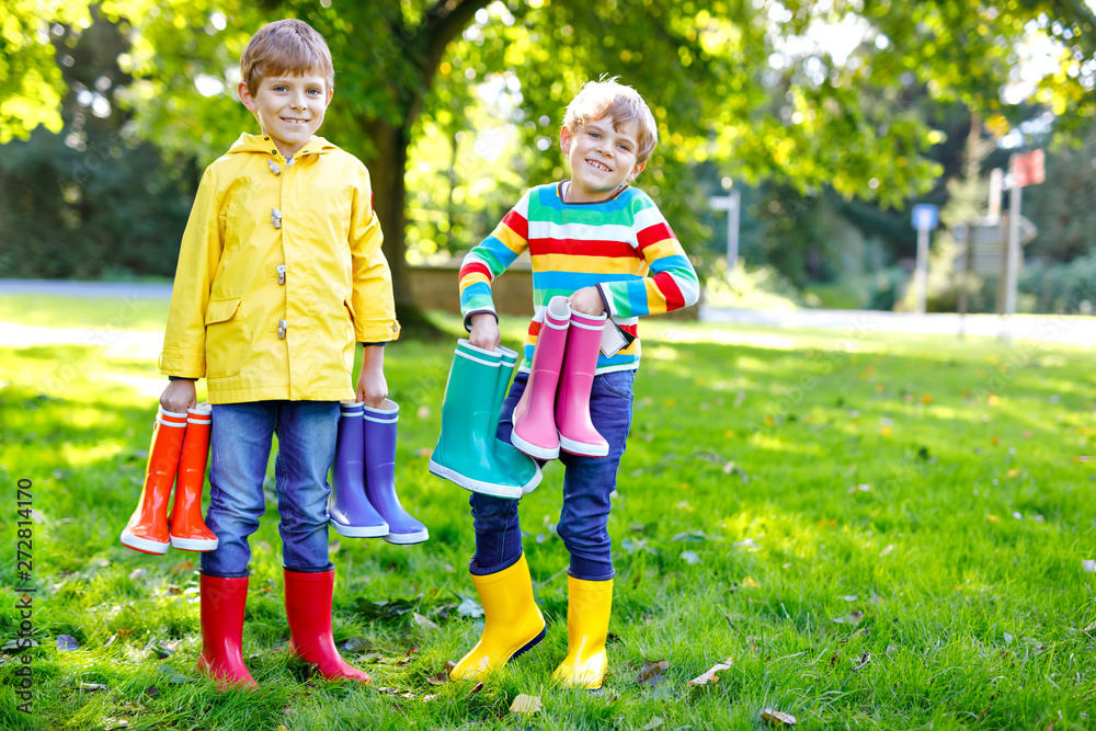 Two little kids boys, cute siblings with lots of colorful rain boots. Children in different rubber boots and jackets. Footwear for rainy fall. Healthy twins and best friends having fun outdoors Two little kids boys, cute siblings with lots of colorful rain boots. Children in different rubber boots and jackets. Footwear for rainy fall. Healthy twins and best friends having fun outdoors